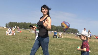  Шустрая девушка, в белой тунике, фотографирует  Никоном, живописный плетень 